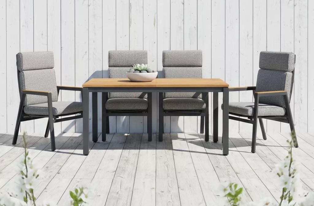 Sitzgruppe mit vier gepolsterten Gartenstühlen an einem Teakholztisch
