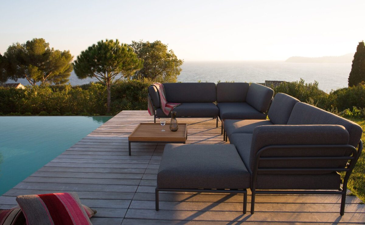 Modulare Lounge mit schlankem Gestell und gemütlichen Polstern an einem Pool