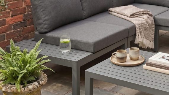 Gemütliches Loungesofa mit Ablage und Tisch auf einer Terrasse